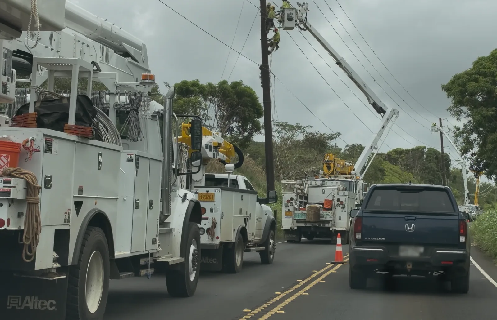 Utility crew repairing transmission lines